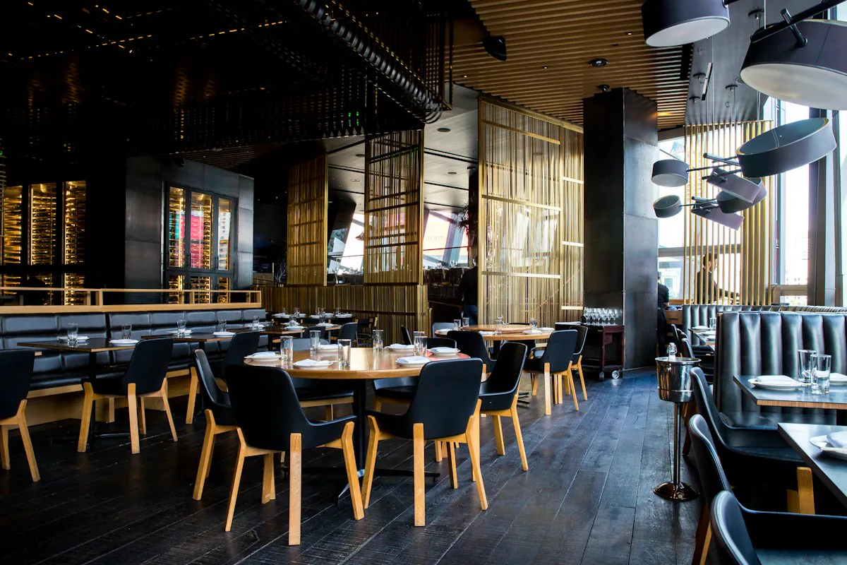 A dark restaurant interior with pendant lighting and wooden partitions