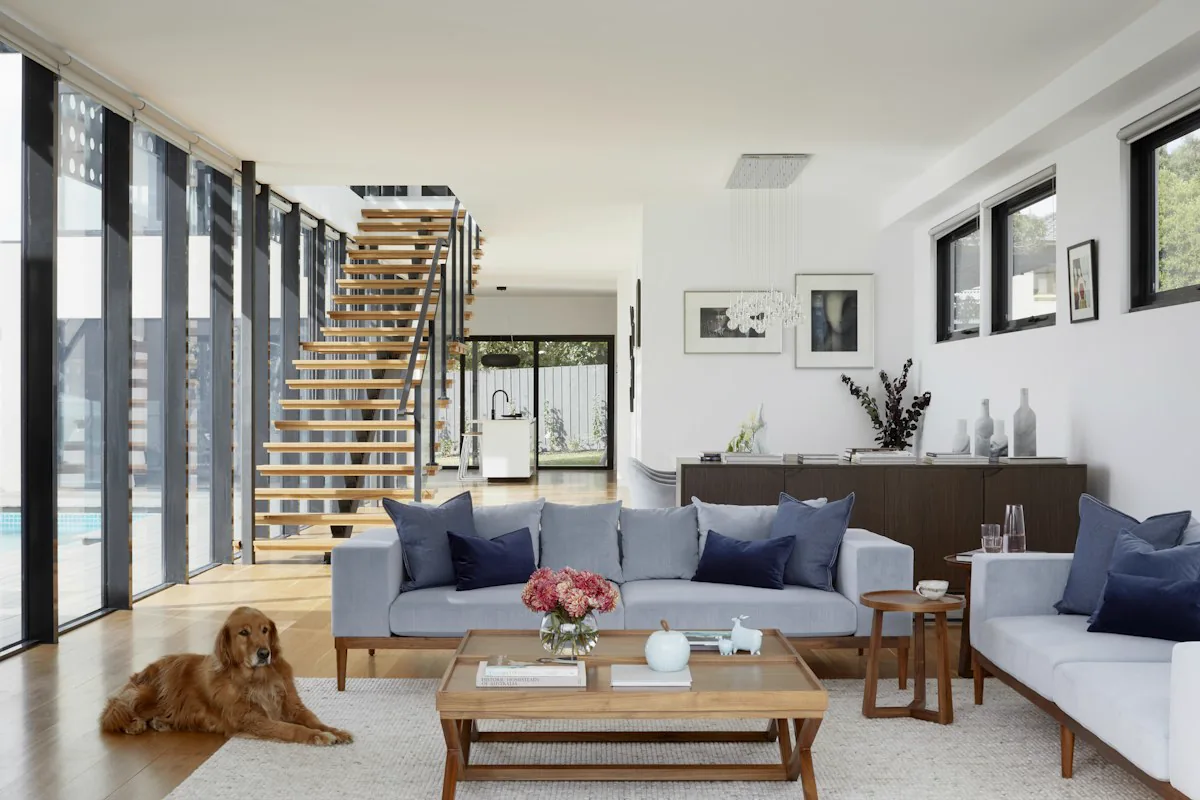A moody dining room with teal walls and a wooden staircase