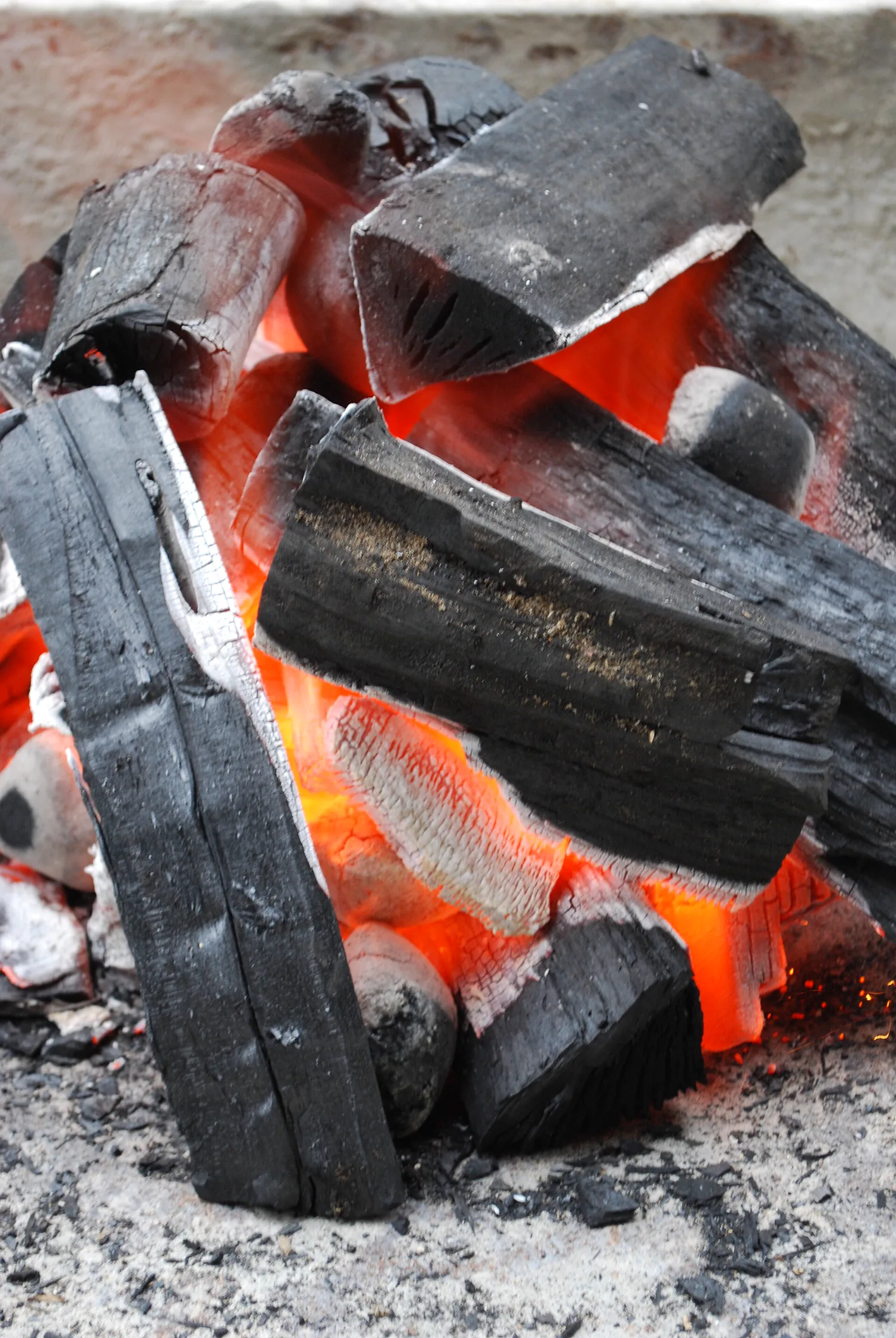 Stacked charcoal briquettes with glowing burning edges